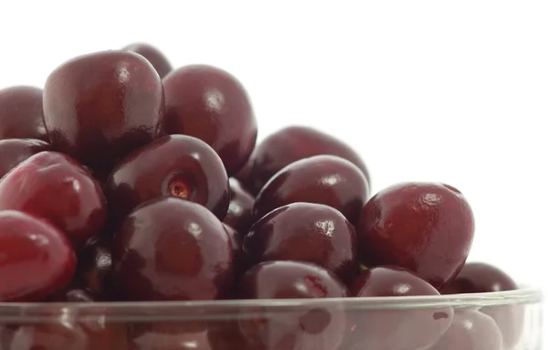 Cerejas em uma tigela em um fundo branco — Fotografia de Stock