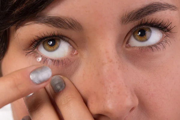 Jovem mulher colocando lente de contato em seu olho. — Fotografia de Stock