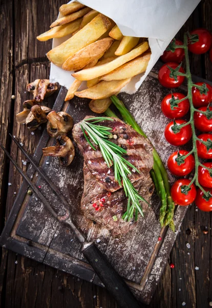 Bifes de carne deliciosos na mesa de madeira — Fotografia de Stock
