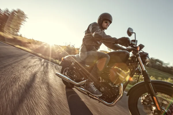 Hombre asiento en la motocicleta en el camino del bosque . — Foto de Stock