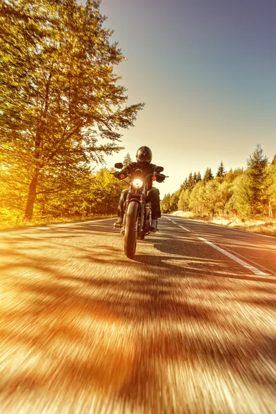 Homem assento na moto na estrada da floresta . — Fotografia de Stock