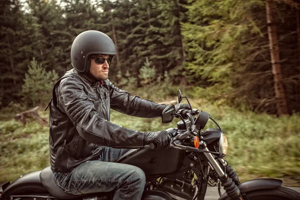 Zetel van de man op de motorfiets op het bos weg. — Stockfoto