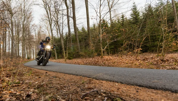 Hombre asiento en la motocicleta en el camino del bosque . — Foto de Stock