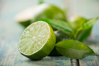 Fresh limes on wooden background clipart