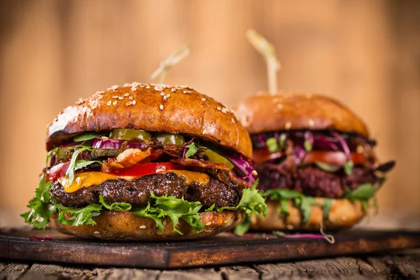 Smakliga hamburgare på träbord. — Stockfoto