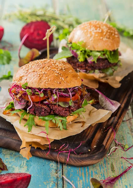 Tasty beef burgers on wooden table. — Stock Photo, Image