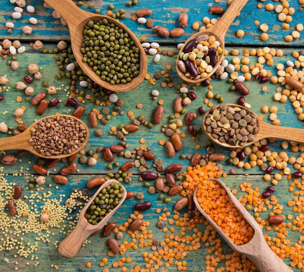 Rohe Hülsenfrüchte auf altem rustikalen Holztisch. — Stockfoto