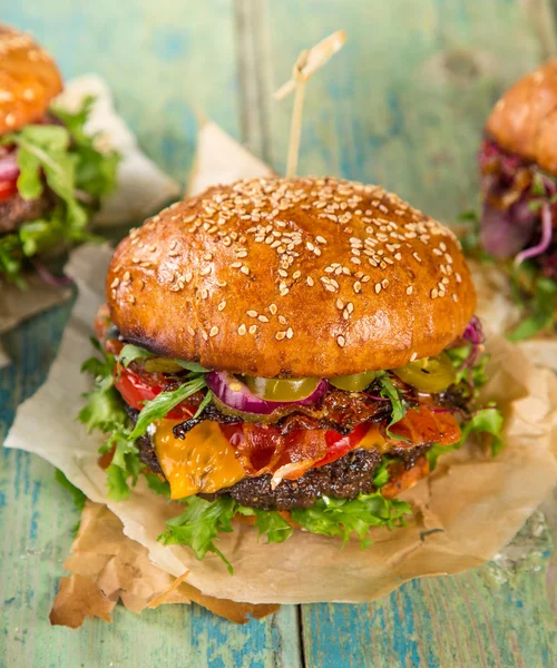 Lekkere hamburgers op houten tafel. — Stockfoto