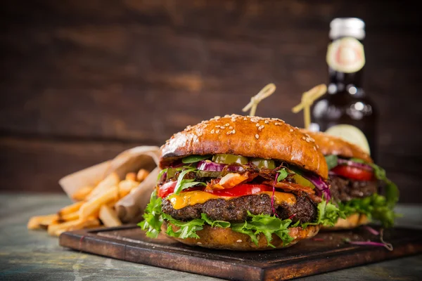 Lekkere hamburgers op houten tafel. — Stockfoto