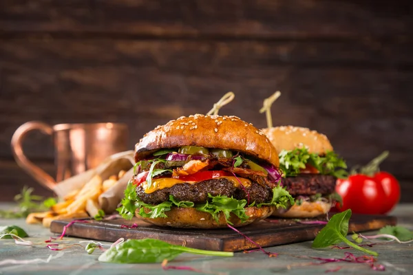 Smakliga hamburgare på träbord. — Stockfoto