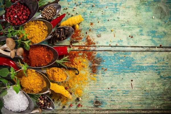 Olika färgglada kryddor på träbord — Stockfoto