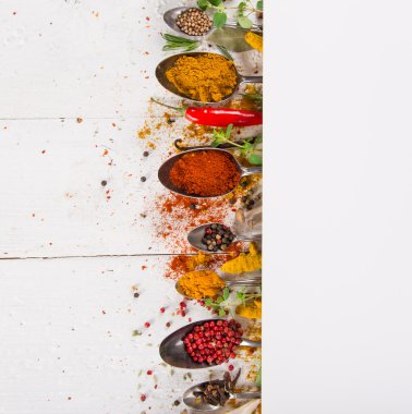 Ahşap masada çeşitli renkli baharatlar var.