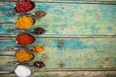 Ahşap masada çeşitli renkli baharatlar var.