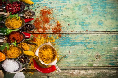 Ahşap masada çeşitli renkli baharatlar var.