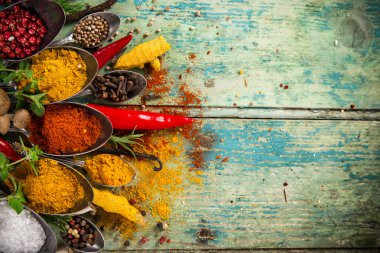Ahşap masada çeşitli renkli baharatlar var.