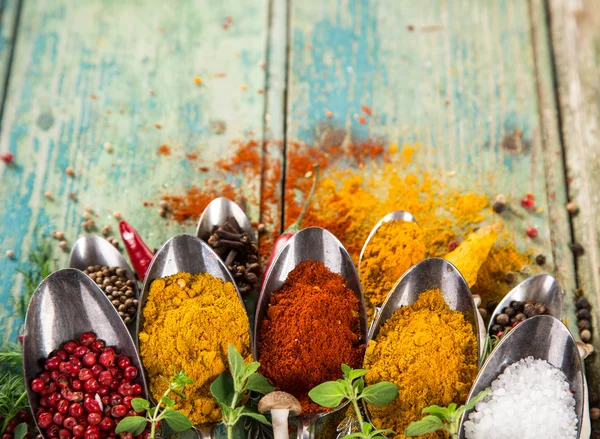 Diverse kleurrijke specerijen op houten tafel — Stockfoto