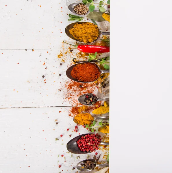 Ahşap masada çeşitli renkli baharatlar var.