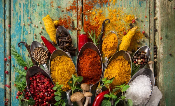 Diverse kleurrijke specerijen op houten tafel — Stockfoto