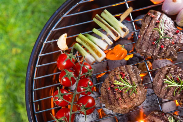 Delicious beef steaks with vegetable on a barbecue grill. — Stock Photo, Image