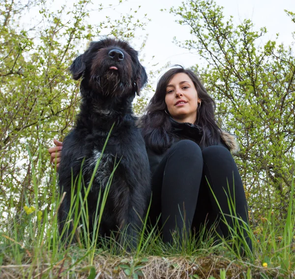 Chica sentada con perro en el prado — Foto de Stock