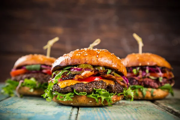 Leckere Burger auf Holztisch. — Stockfoto