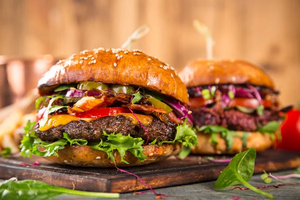 Smakliga hamburgare på träbord. — Stockfoto