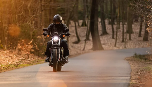 Hombre asiento en la motocicleta en el camino del bosque . — Foto de Stock