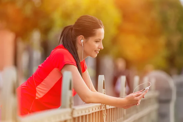 Young woman listening to music during sunny day in the city. — Stock Photo, Image