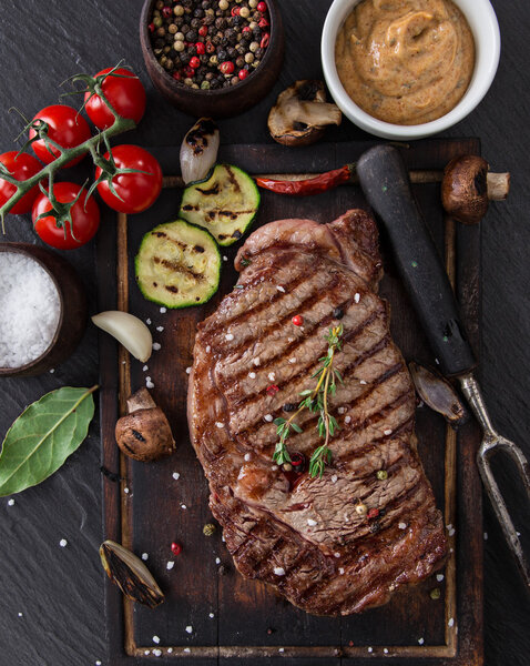 Вкусный стейк из говядины на черном столе
.