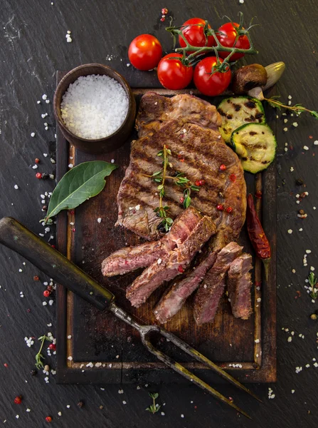 Delicious beef steak on black stone table. — Stock Photo, Image