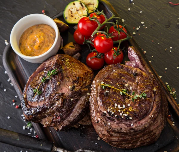 Delicious beef steak on black stone table. — Stock Photo, Image