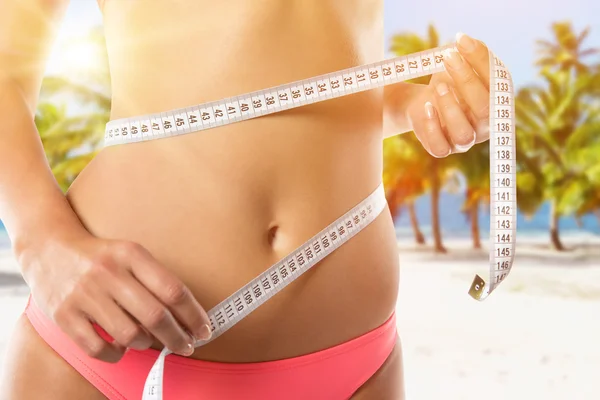 A slim girl measuring her waist. — Stock Photo, Image