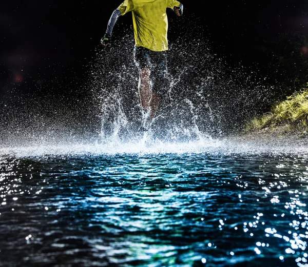 Coureur unique courant, faisant éclabousser dans un ruisseau . — Photo