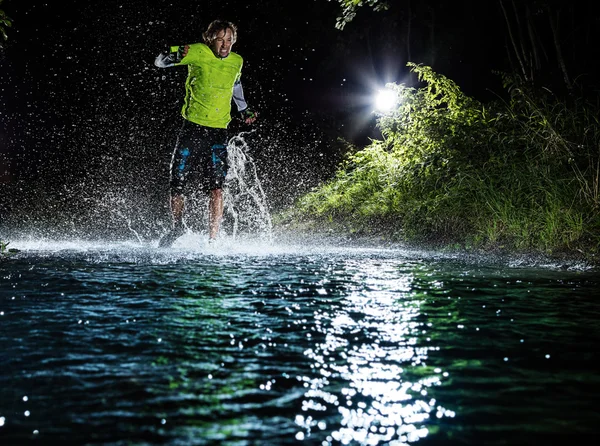 Single runner running, making splash in a stream. — Stock Photo, Image