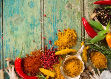 Ahşap masada çeşitli renkli baharatlar var.
