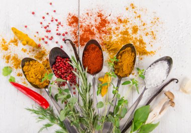 Ahşap masada çeşitli renkli baharatlar var.