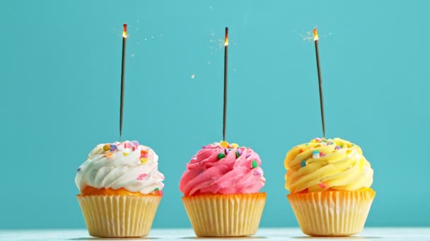 Cupcake di compleanno con brillantini ardenti su sfondo blu pastello. Super rallentatore. — Video Stock