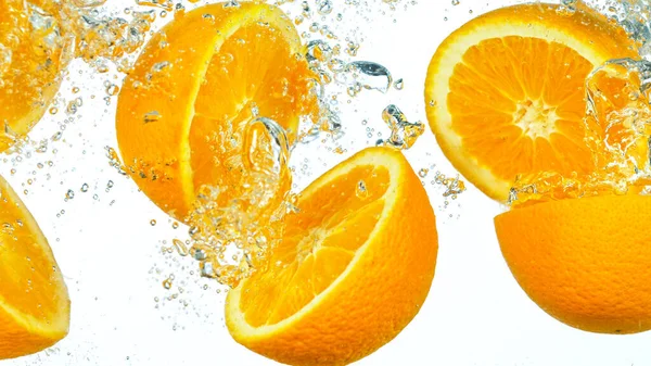 Frische Orangenscheiben spritzen ins Wasser — Stockfoto