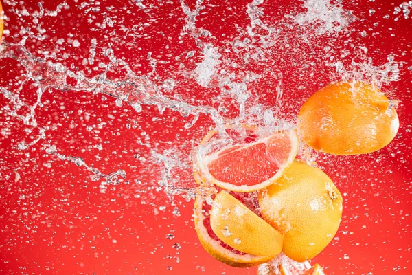 Rodajas de toronja fresca con salpicadura de agua —  Fotos de Stock