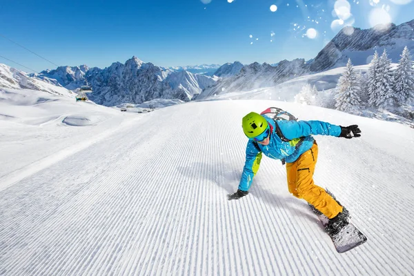 Snowboardista sjíždí z kopce ve vysokých horách — Stock fotografie