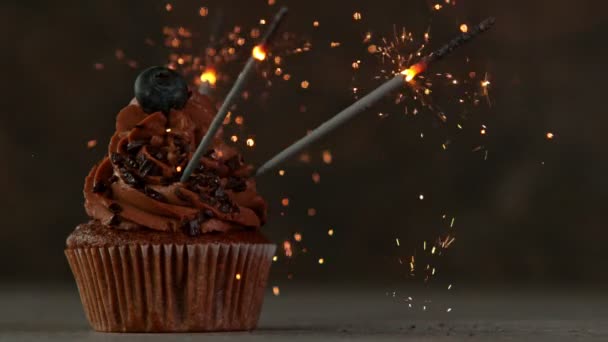 Choklad Cupcake med brännande gnistrar på mörk sten bakgrund. Superlångsamma rörelser. — Stockvideo