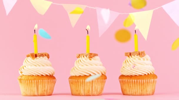 Cupcakes With Burning Colorful Candles on Pastel Pink Background. Super cámara lenta. — Vídeos de Stock