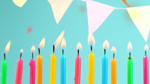 Cumpleaños quema velas de colores sobre fondo azul pastel. Super cámara lenta. — Vídeo de stock