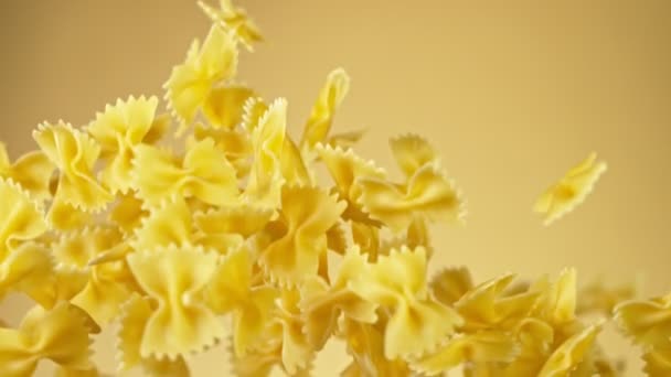 Дуже повільний рух неприготованої італійської макарони на золотому тлі. — стокове відео