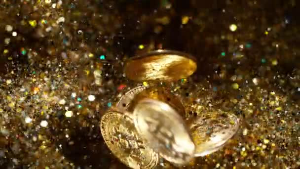 Криптовалюты Биткоины летают с золотыми блестками. 4k, 1000 кадров в секунду. — стоковое видео