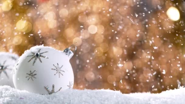 Christmas Still Life com luzes no fundo e flocos de neve caindo. Movimento super lento. — Vídeo de Stock