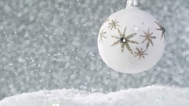 Kerststilleven met lichten op de achtergrond en sneeuwvlokken vallen. Super Slow Motion. — Stockvideo