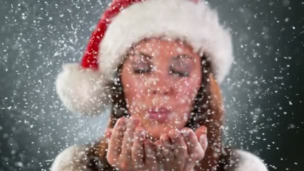 Mooie Kerstman vrouw blaast sneeuw uit haar handen naar de camera. Super Slow Motion. — Stockvideo