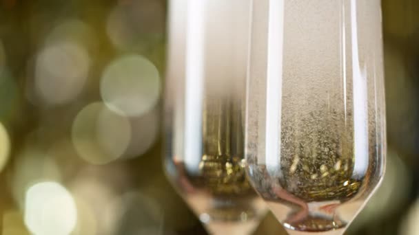 Flöjter med mousserande champagne vin över Golden Bokeh Blinking bakgrund. — Stockvideo