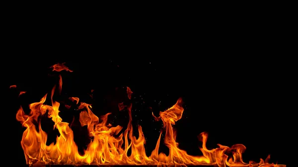 Chamas de fogo com faíscas sobre fundo preto — Fotografia de Stock
